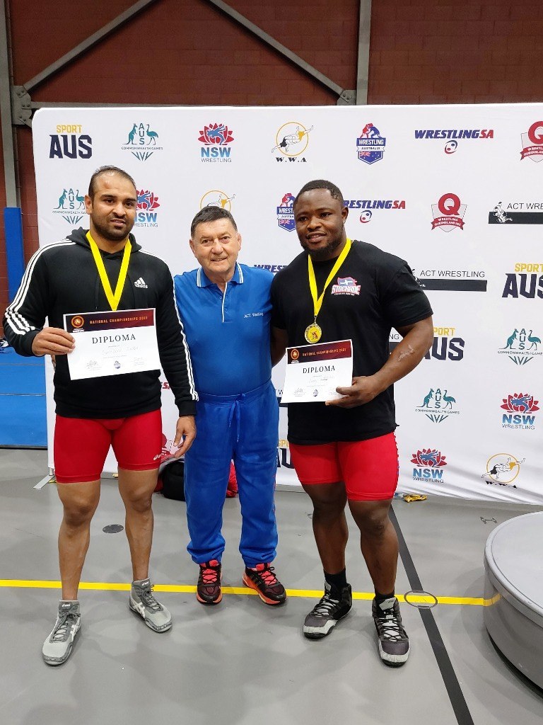 ACT wrestlers with medals and diplomas beside their coach at an Australian national wrestling championship