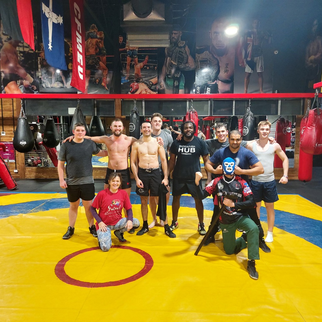 Wrestlers and coaches gathered on the mat after a training session at a Canberra wrestling club
